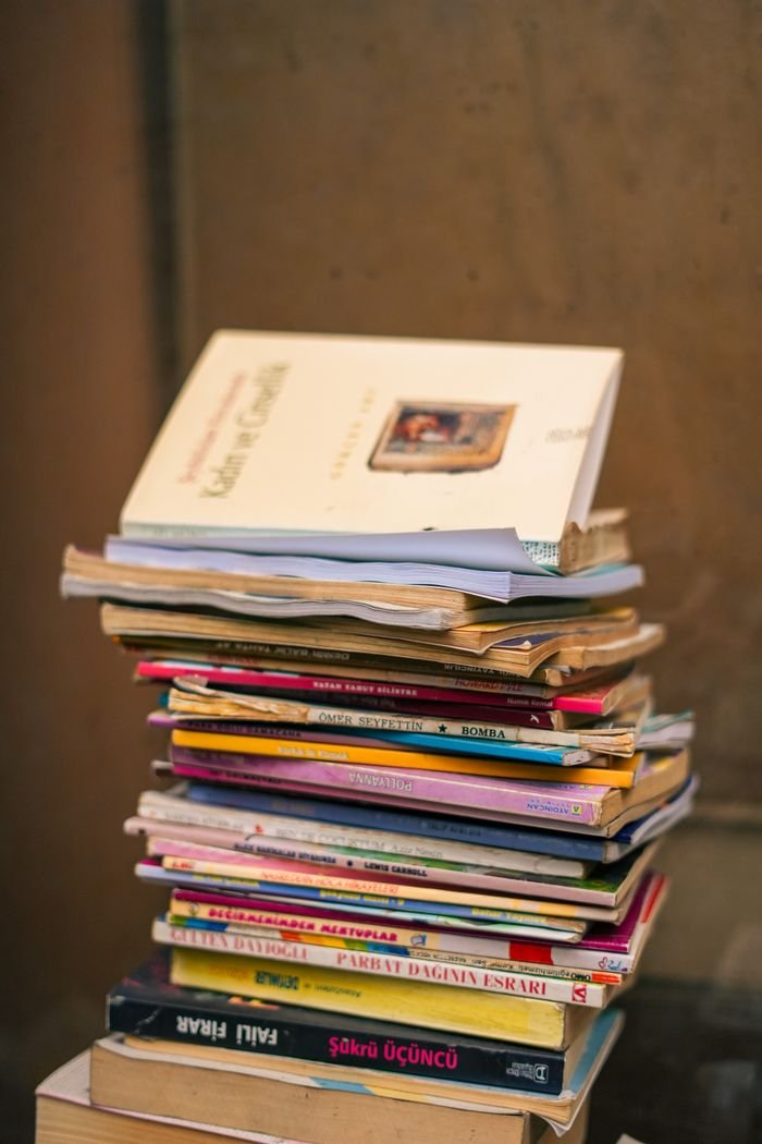 A vertical stack of colorful books against a brown backdrop. Ideal for educational themes.