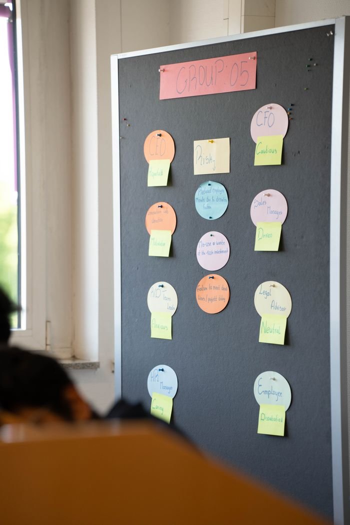Photo of a bulletin board with colorful sticky notes in an office setting.